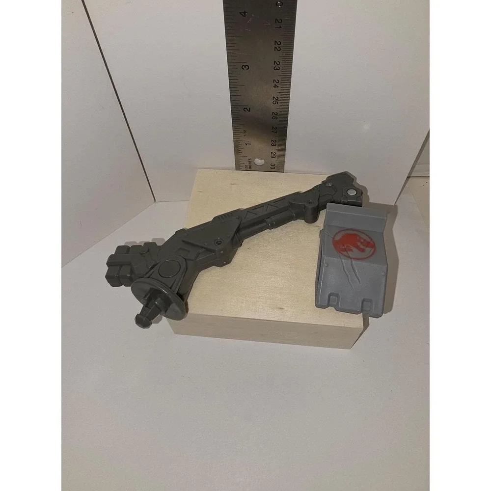 Jurassic World or similar action figure line, featuring a gray grapple-like arm